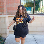 A girl modeling a blue shirt with “Confident & Kind” in half yellow and half orange organic fond. The words are surrounded by various flowers and stars - from Sierra Schultzzie