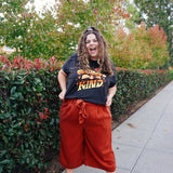 A girl modeling a blue shirt with “Confident & Kind” in half yellow and half orange organic fond. The words are surrounded by various flowers and stars - from Sierra Schultzzie