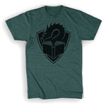 A tealish green colored t-shirt with a centered large black illustration of a dragon's head peering at the pages of an open book, with a crest shape in the background. 