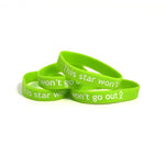 Four lime green bracelets that say “This star won’t go out” in white sans serif font followed by a ribbon - from This Star Won’t Go Out