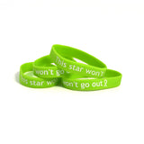 Four lime green bracelets that say “This star won’t go out” in white sans serif font followed by a ribbon - from This Star Won’t Go Out