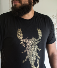 Tyler Thrasher modeling a dark gray shirt with white line drawn flowers arranged to make a scorpion in the center of the shirt - from Tyler Thrasher