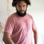Tyler Thrasher modeling a red shirt with a dark red silhouette of a thistle weed in the center of the shirt. “Hands off” is written on the top of the thistle weed in red sans serif font - from Tyler Thrasher