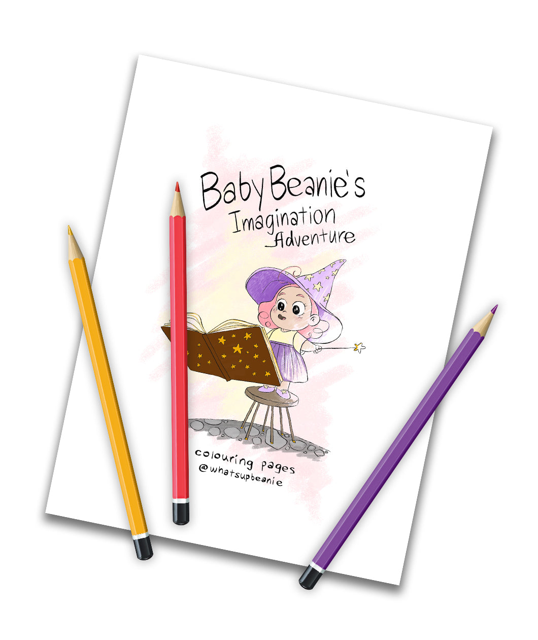 Three colored pencils are strewn across a page of paper that says "Baby Beanie's Imagination Adventure" "Colouring Pages @whatsupbeanie." On the paper is an illustration of a girl in purple and yellow wizard garb, a floating magical book in front of her.